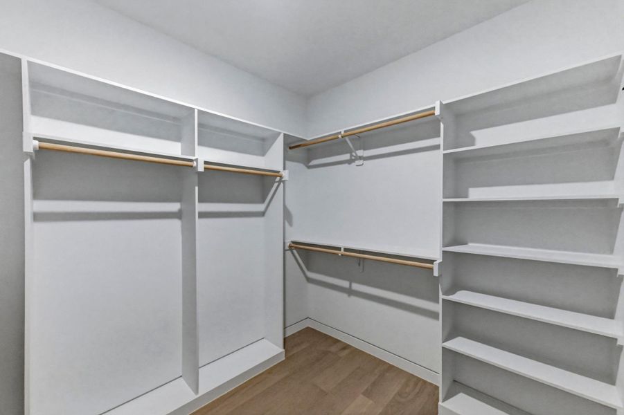 Walk in closet with light wood-style floors