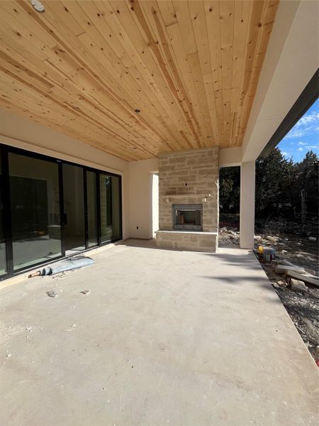 Extended patio with tongue and groove ceiling and fireplace.