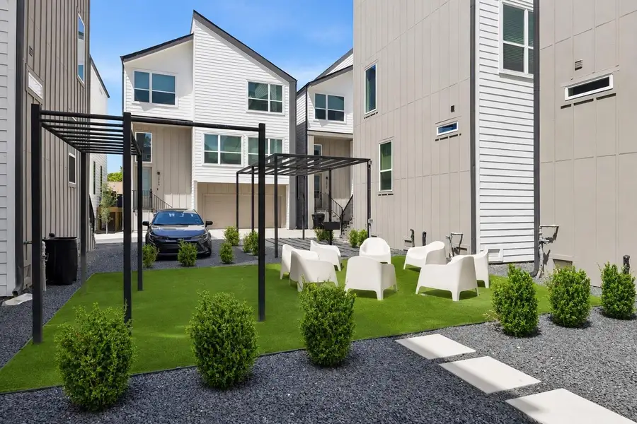 Landscaped community gathering space features pergolas, green space, and comfortable seating designed for neighbors to relax, connect, and enjoy the outdoors.