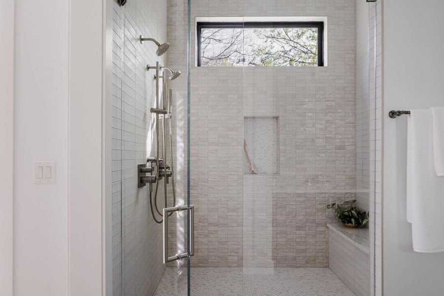 The walk-in shower is finished with chic tile selections, dual heads, and clean glass detailing for a modern, elevated feel. The walk-in shower is finished with chic tile selections, dual heads, and clean glass detailing for a modern, elevated feel.