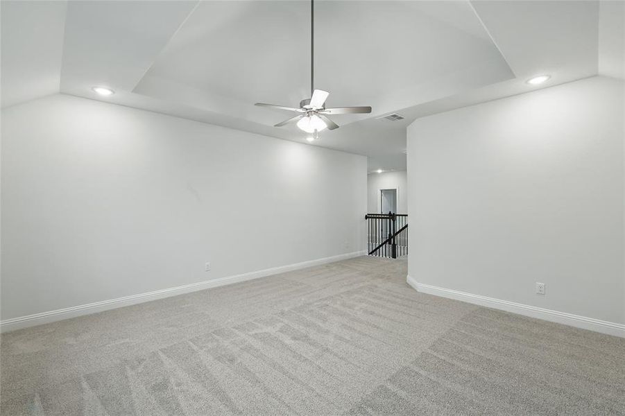 Spare room with recessed lighting, light carpet, a ceiling fan, vaulted ceiling, and baseboards