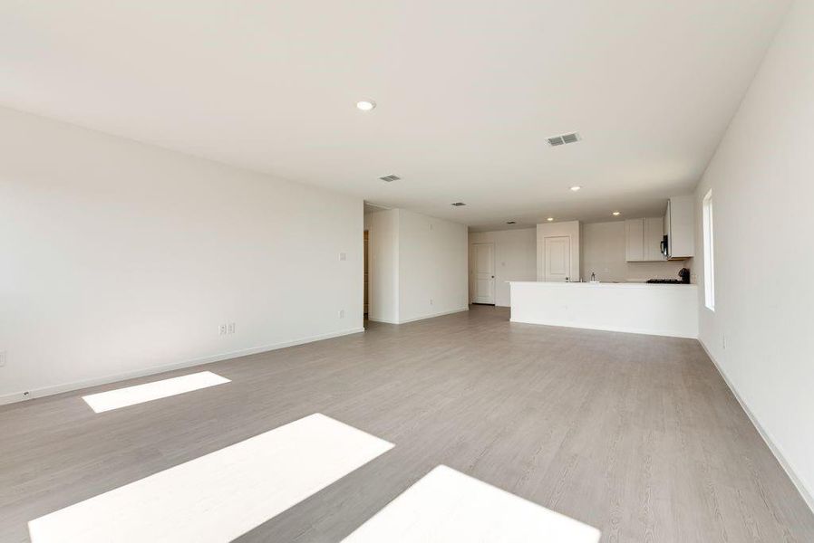 Unfurnished living room with recessed lighting, baseboards, visible vents, and light wood finished floors