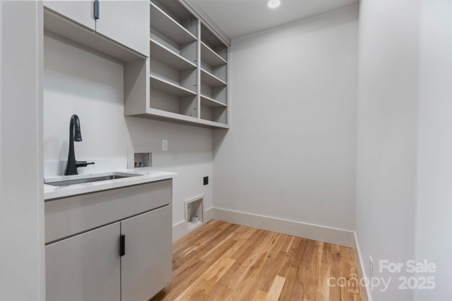 Main level laundry room provides sink and storage Main level laundry room provides sink and storage