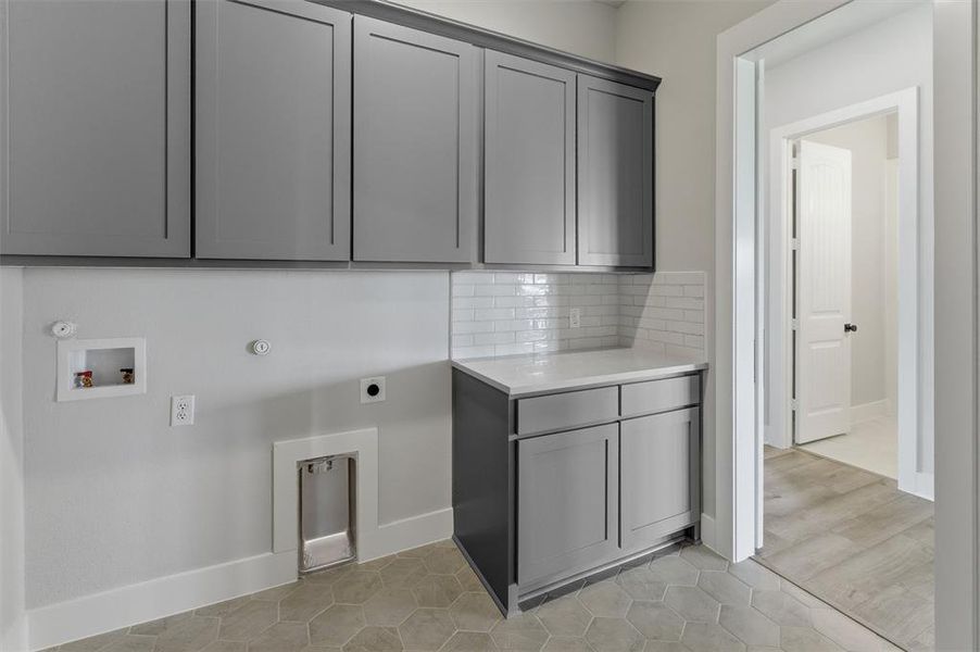 Laundry room with hookup for a gas dryer, washer hookup, electric dryer hookup, light tile patterned floors, and cabinet space