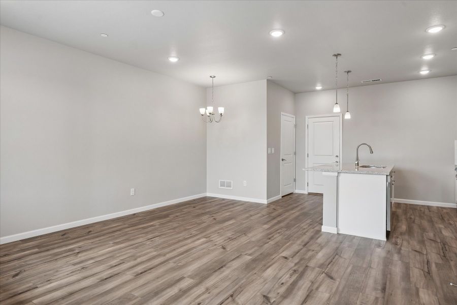 A room with a wood floor and white cabinets.