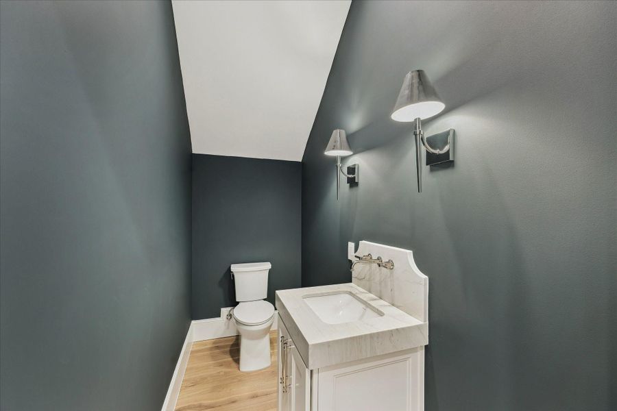 First floor powder features timeless Mont Blanc Quartzite countertop, Kallista luxury fixtures and undermount sink, and additional storage and pendent lights.