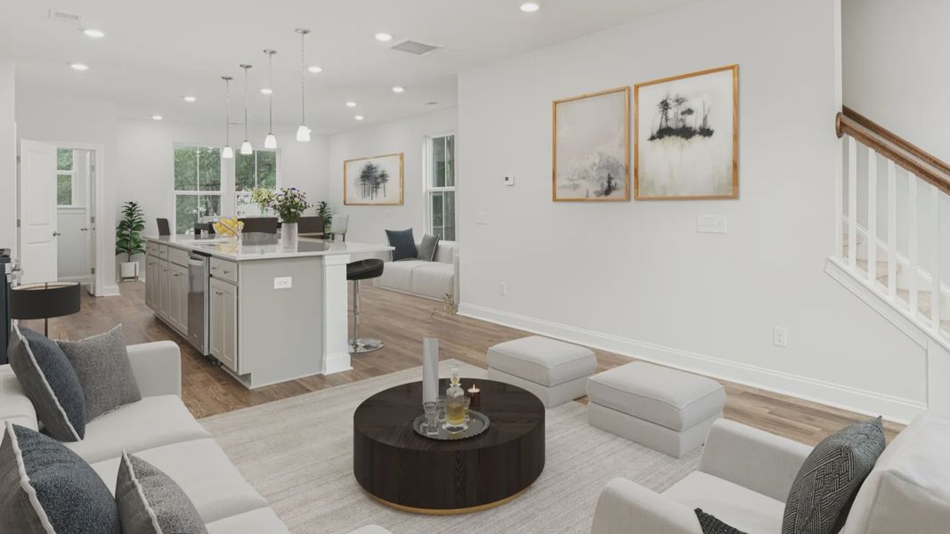 Living room with seating and island kitchen in a DRB Homes Brookgreen model