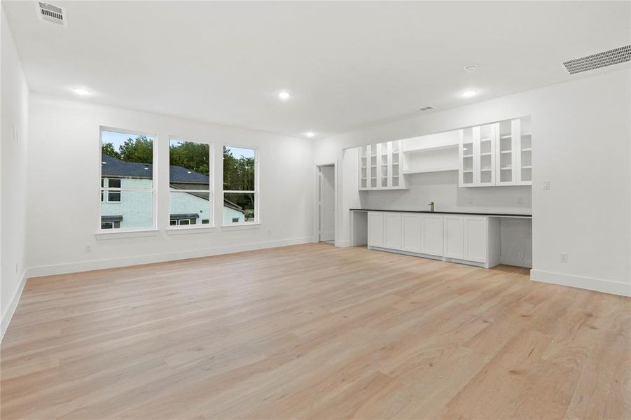 Unfurnished living room with light wood-type flooring and recessed lighting Unfurnished living room with light wood-type flooring and recessed lighting