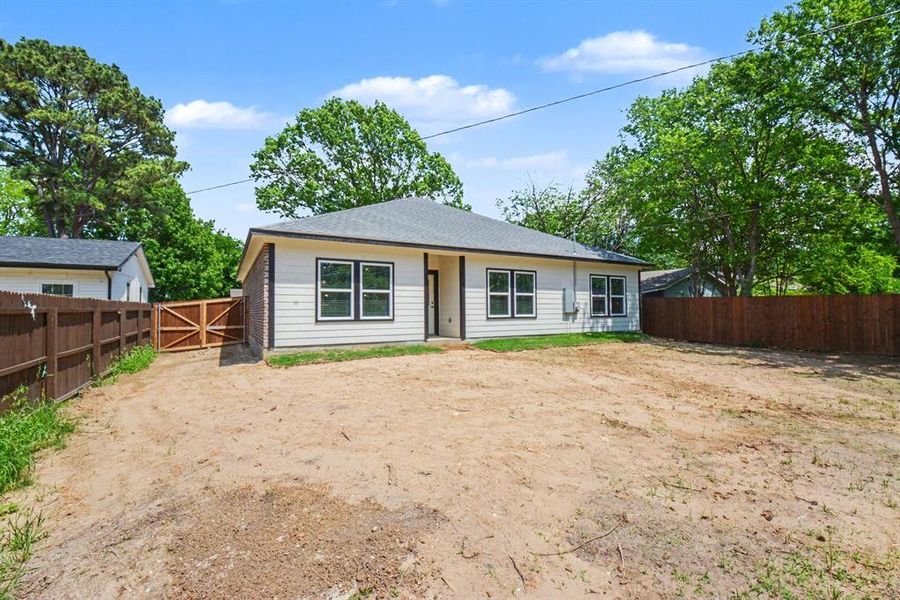 The property features a single-story residence with light-colored siding, a dark roof, and dark-framed windows