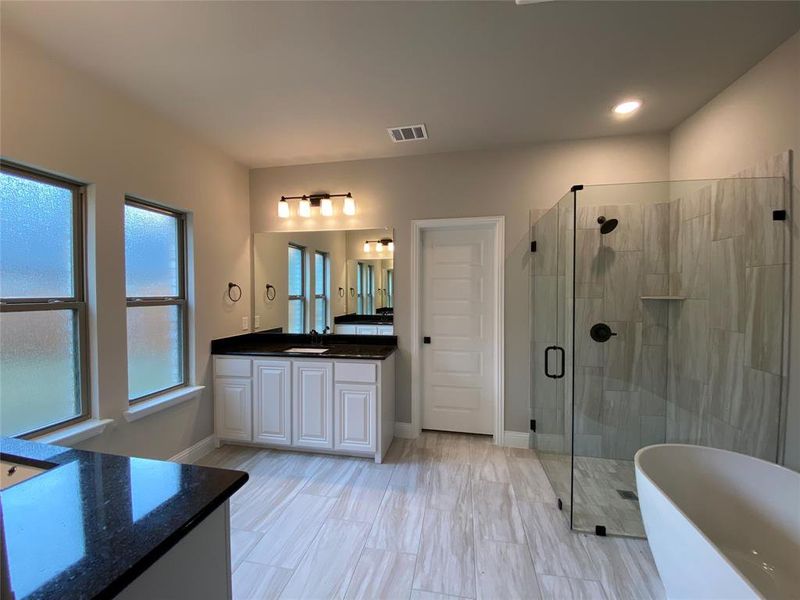 Spa-like master bath has 12x24 grey tile, white cabs, black granite, and 2 separate vanities Spa-like master bath has 12x24 grey tile, white cabs, black granite, and 2 separate vanities