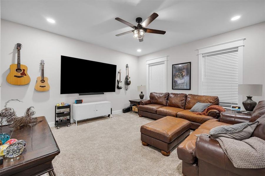 Carpeted living room featuring ceiling fan