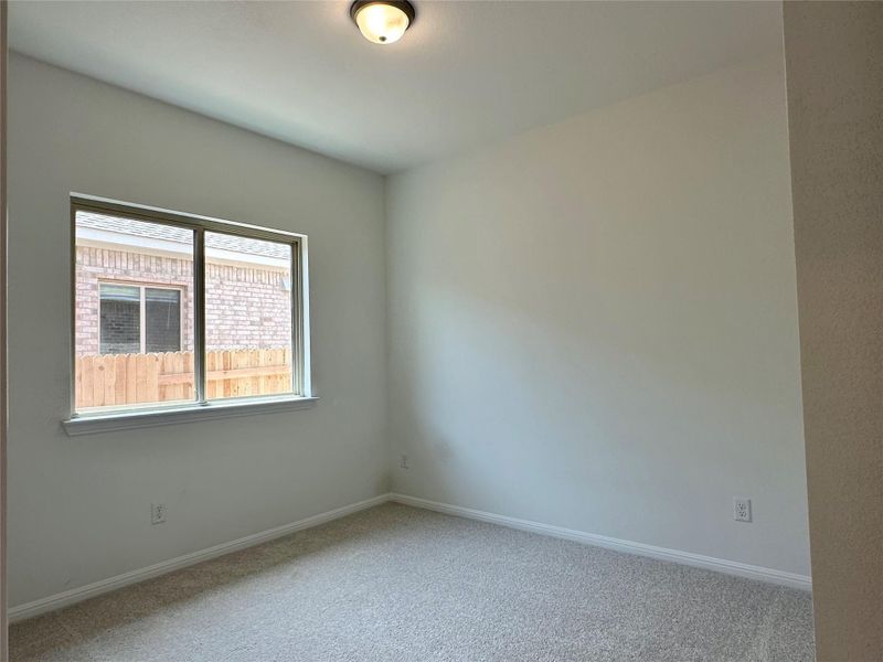 Carpeted spare room featuring baseboards