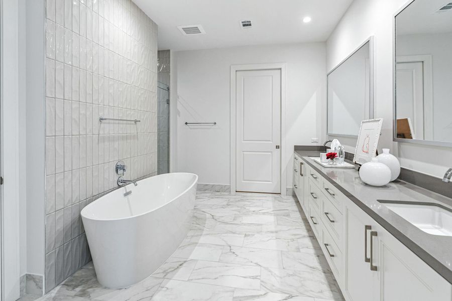 An impressive luxury primary bathroom is every owner's dream. Dual vanities, free standing soaking tub and a door leading to one of the two primary dressing rooms An impressive luxury primary bathroom is every owner's dream. Dual vanities, free standing soaking tub and a door leading to one of the two primary dressing rooms