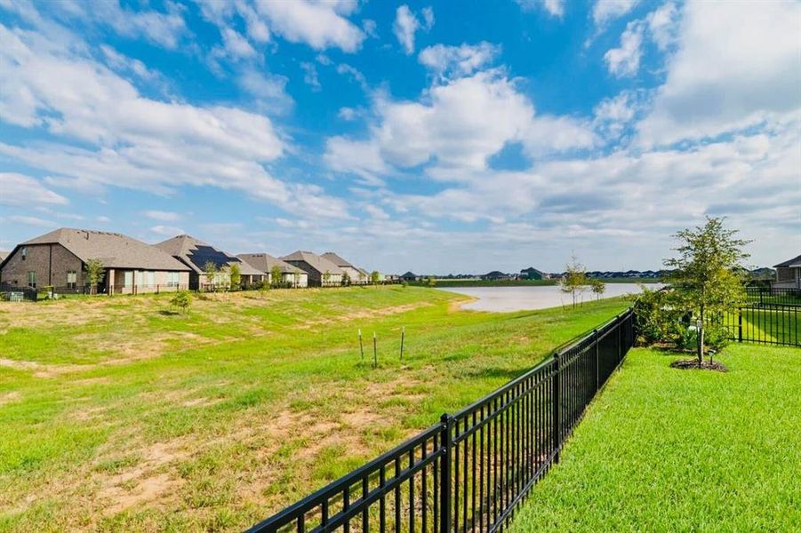 Serene water views, wrought iron fence and lush green space, perfect for relaxation and outdoor activities