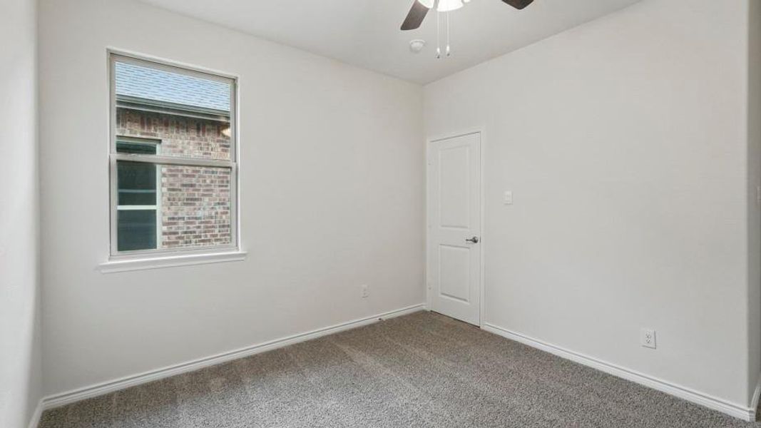 Neutral wall color, grey carpet flooring, white trim, and a ceiling fan with integrated lighting