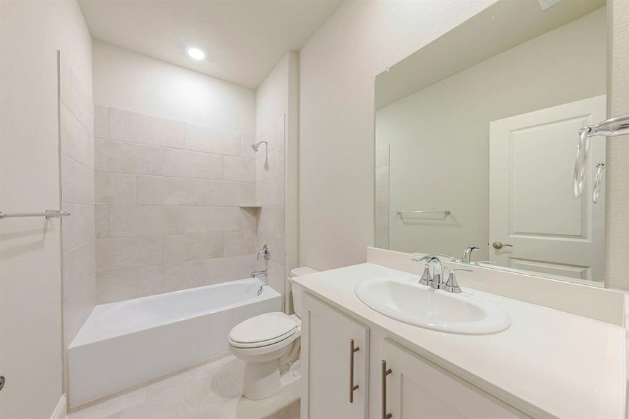 Full bath featuring shower / tub combination, vanity, tile patterned floors, and recessed lighting Full bath featuring shower / tub combination, vanity, tile patterned floors, and recessed lighting