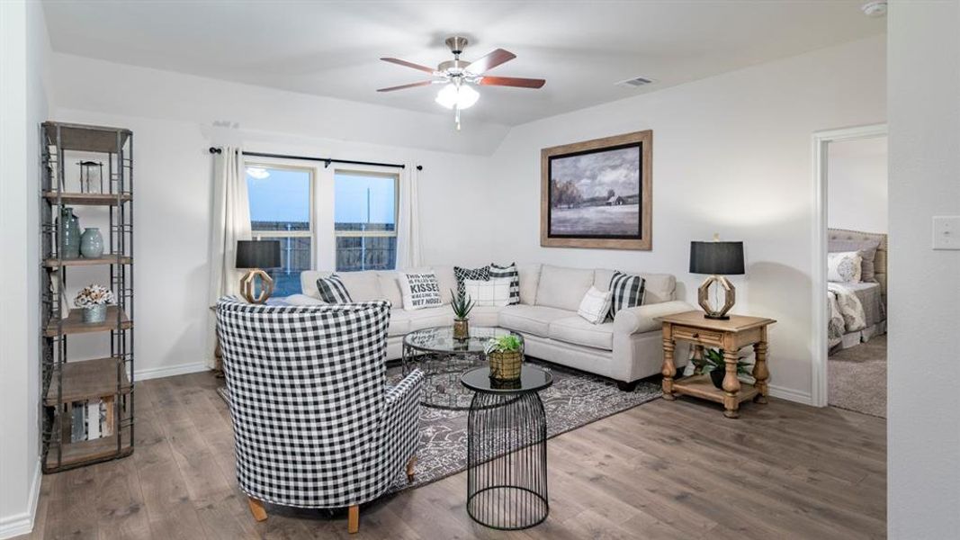 Living area featuring wood finished floors and a ceiling fan Living area featuring wood finished floors and a ceiling fan