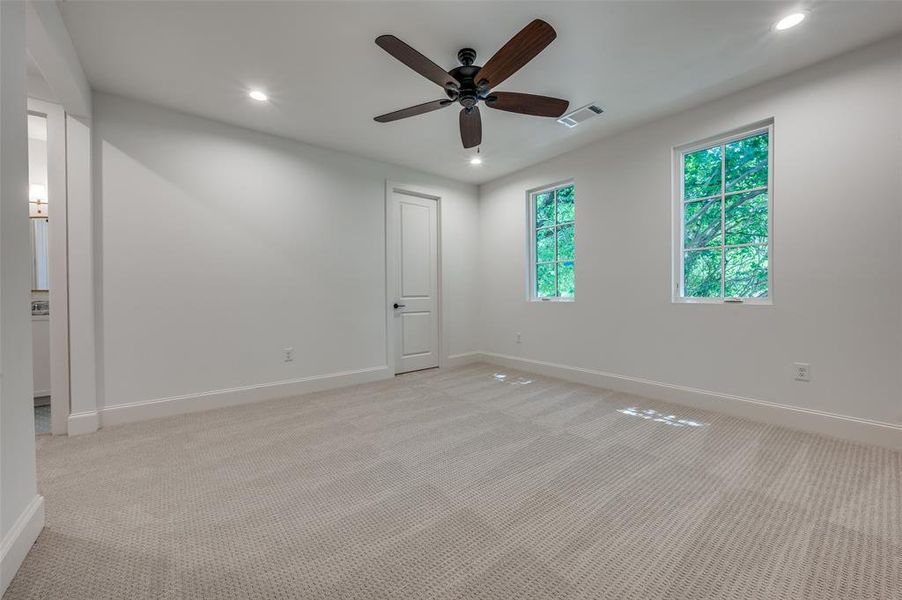 Unfurnished bedroom with light carpet, ceiling fan, and recessed lighting Unfurnished bedroom with light carpet, ceiling fan, and recessed lighting