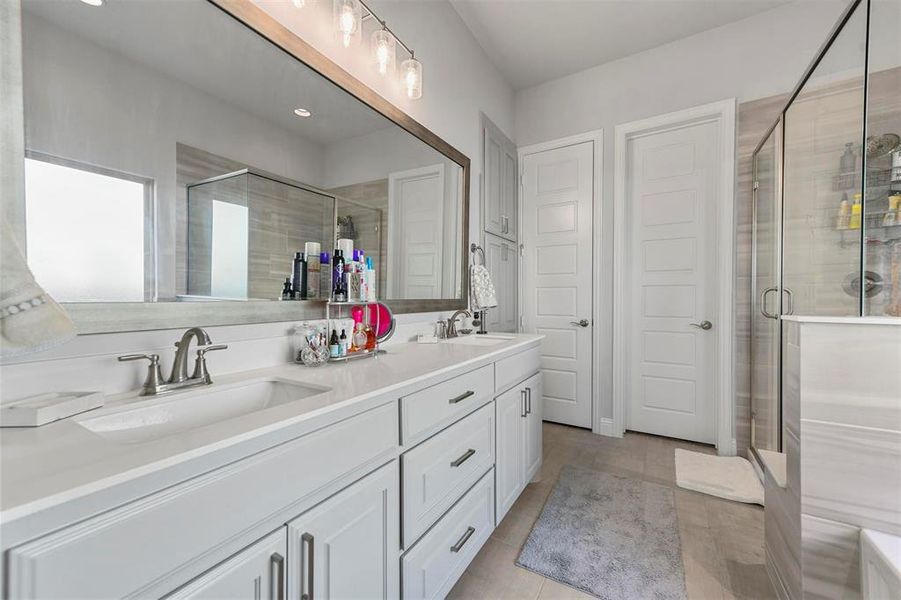 Bathroom featuring walk in shower, vanity, and tile patterned floors