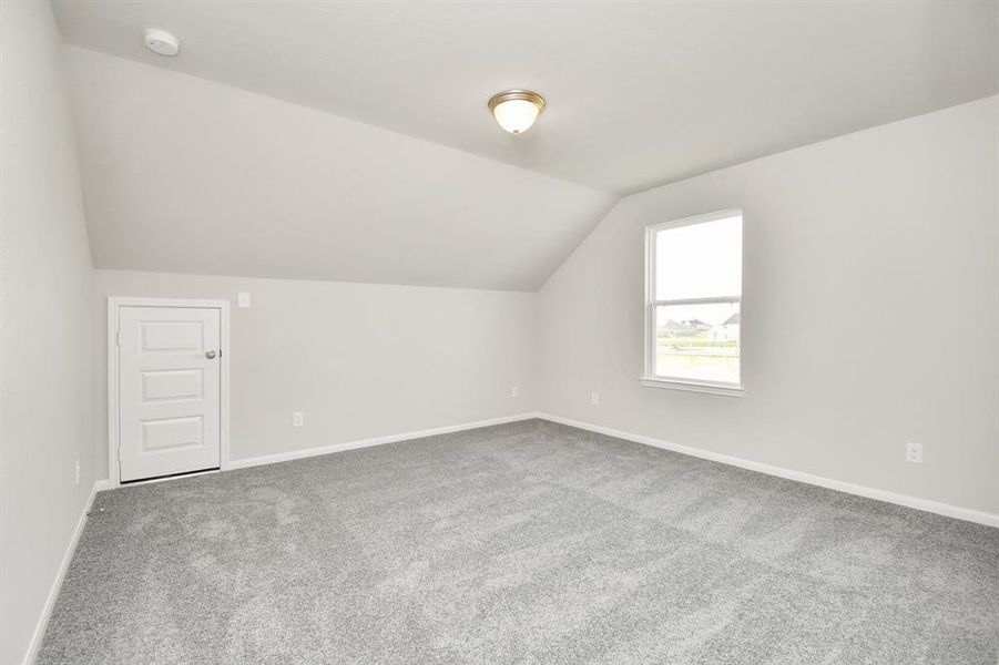 Fifth bedroom features plush carpet and large window.