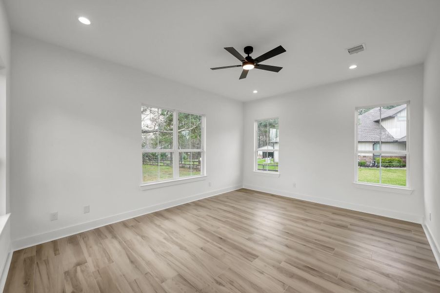 Expansive primary suite with large windows that fill the room with natural light and provide peaceful views of the property. Neutral tones and high ceilings create a relaxing retreat.