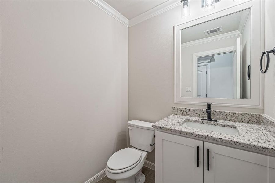 Bathroom featuring crown molding and vanity