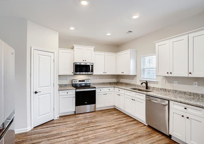 Incredible kitchen with granite countertops, stainless appliances, and wood-style flooring.