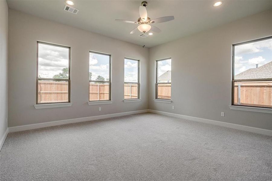 Carpeted empty room featuring ceiling fan