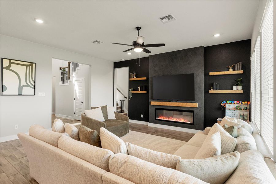 A well-lit living area showcases a sleek fireplace and a stairway to the second floor. A well-lit living area showcases a sleek fireplace and a stairway to the second floor.