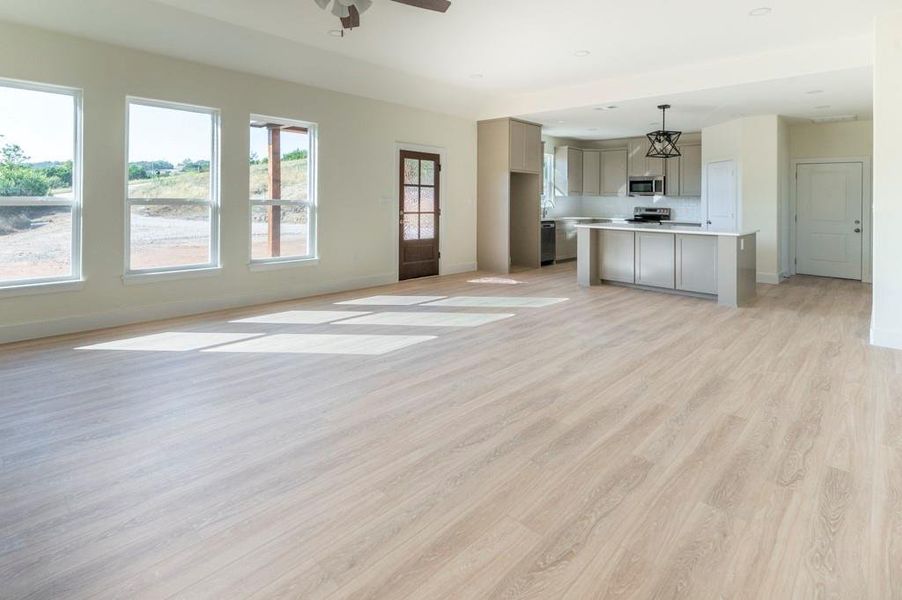 Unfurnished living room featuring light wood-style floors and ceiling fan