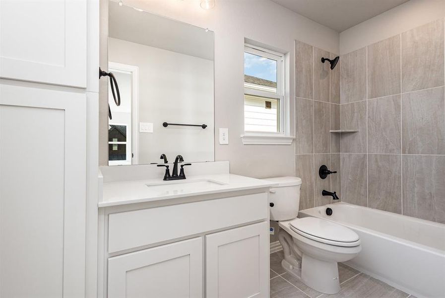 Full bath featuring bathtub / shower combination, vanity, and light tile patterned flooring