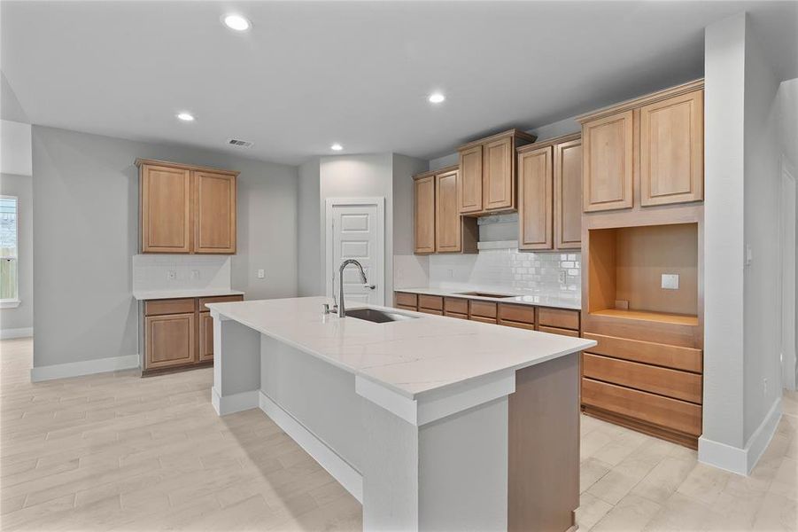 This kitchen is by far any chef’s dream! This spacious kitchen features high ceilings, stained wood cabinets, quartz countertops, SS appliances, modern tile backsplash, recessed lighting, quartz kitchen island with space for breakfast bar and extra storage, and a walk-in pantry all overlooking your huge family room.