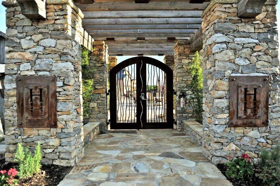 Entrance to property with stone siding and a gate Entrance to property with stone siding and a gate