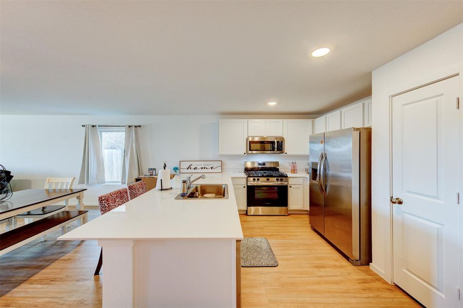 As you turn the corner, the home opens up to the kitchen, with plenty of cabinet and counter space and stainless steel appliances.