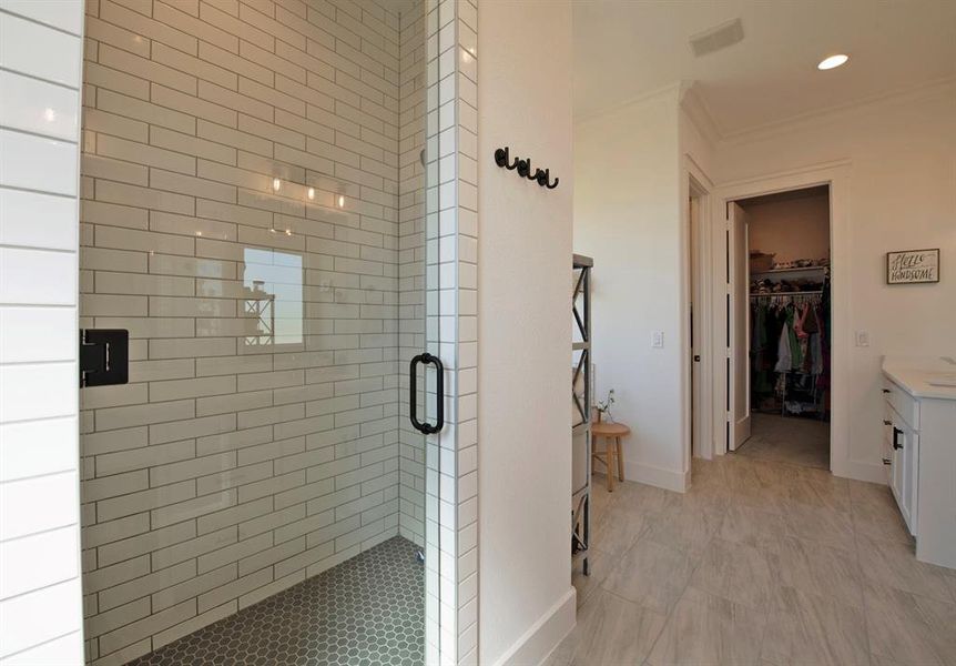 Bathroom featuring a walk in closet, vanity, a stall shower, ornamental molding, and recessed lighting