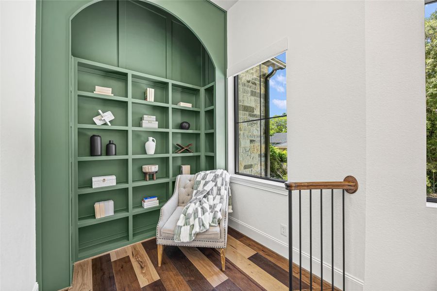 A beautifully styled nook at the top of the stairs, featuring a custom arched built-in and a cozy seating area bathed in natural light. A beautifully styled nook at the top of the stairs, featuring a custom arched built-in and a cozy seating area bathed in natural light.