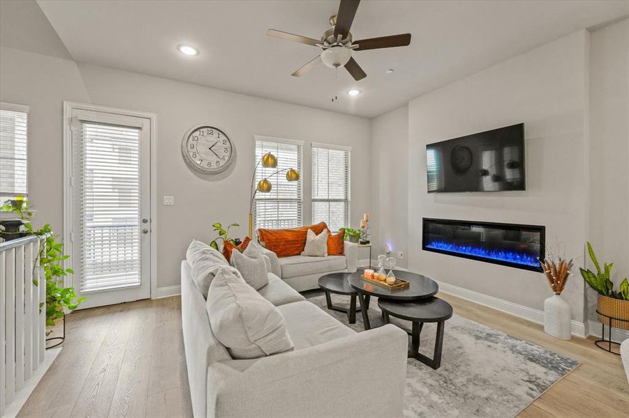 Living room with ceiling fan and light hardwood / wood-style flooring