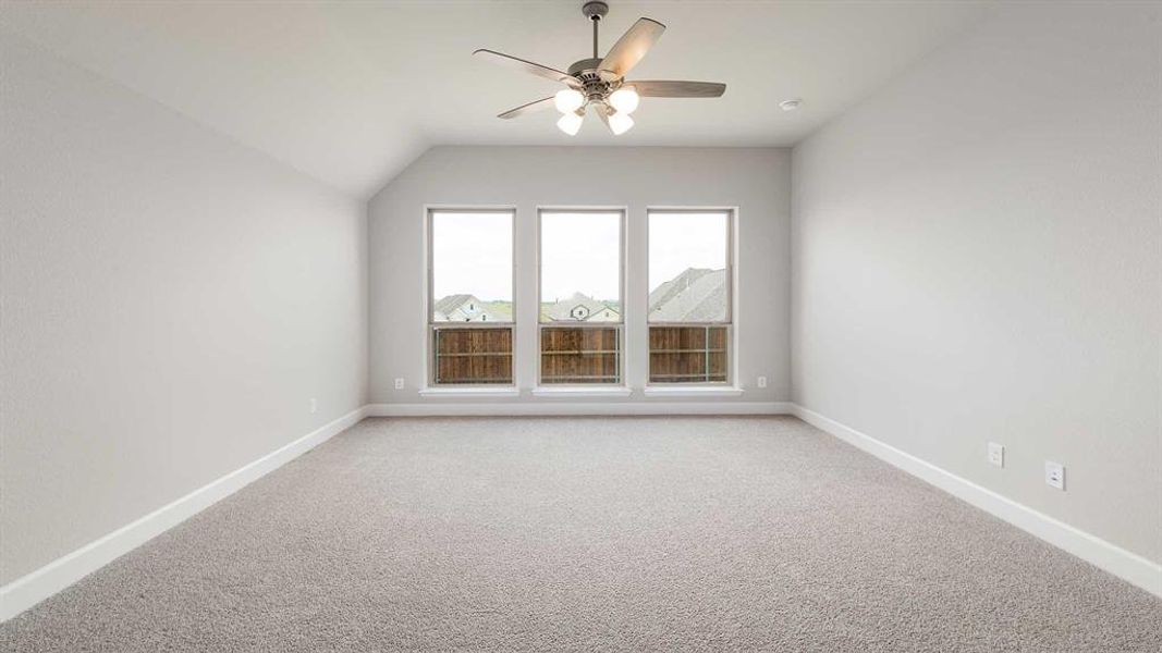 Additional living space featuring carpet floors, ceiling fan, and lofted ceiling