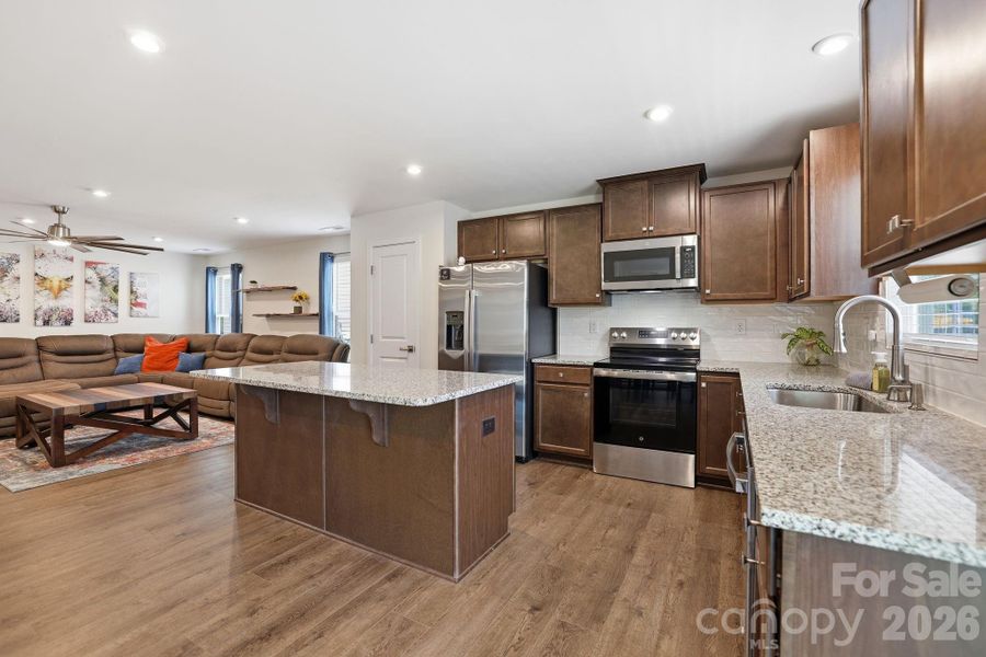 Kitchen is the heart of the home with stacked cabinets, granite counters &