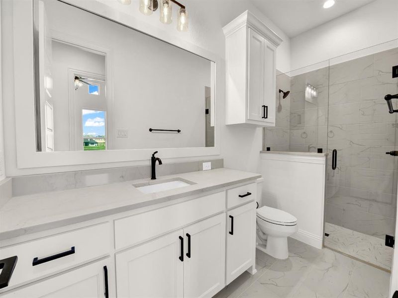 Full bath featuring toilet, recessed lighting, vanity, a marble finish shower, and marble finish floor Full bath featuring toilet, recessed lighting, vanity, a marble finish shower, and marble finish floor