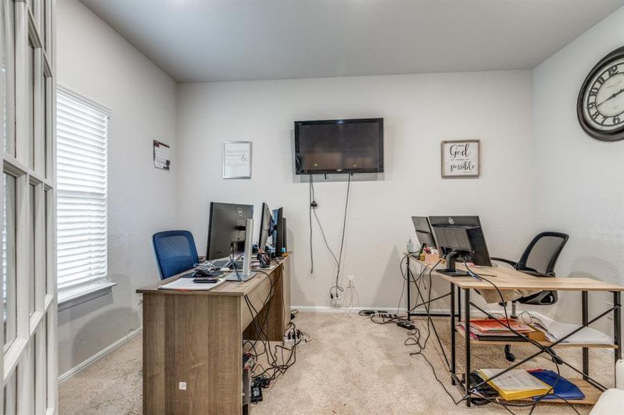 Office with light colored carpet and baseboards