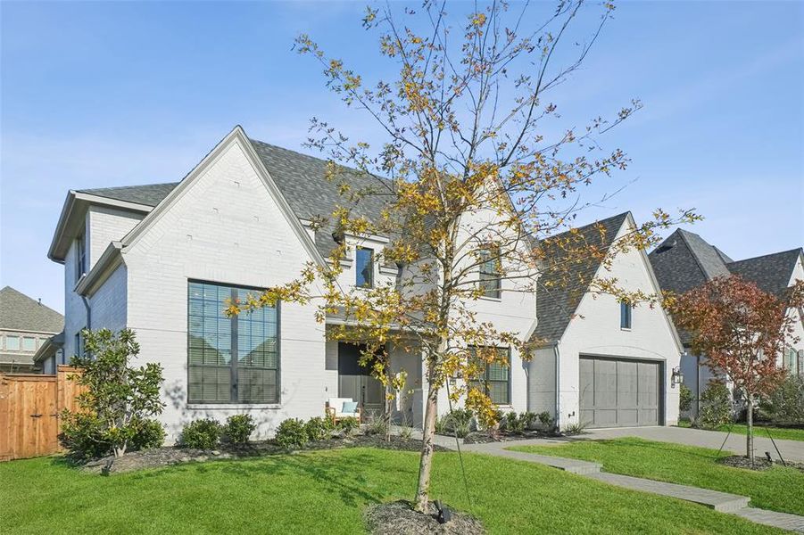French provincial home featuring brick siding, concrete driveway, roof with shingles, and a garage French provincial home featuring brick siding, concrete driveway, roof with shingles, and a garage