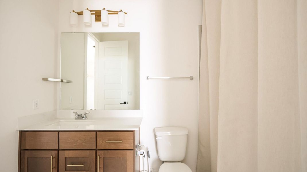 A well-appointed bathroom features a contemporary vanity and a pristine toilet, ready for daily routines. A well-appointed bathroom features a contemporary vanity and a pristine toilet, ready for daily routines.