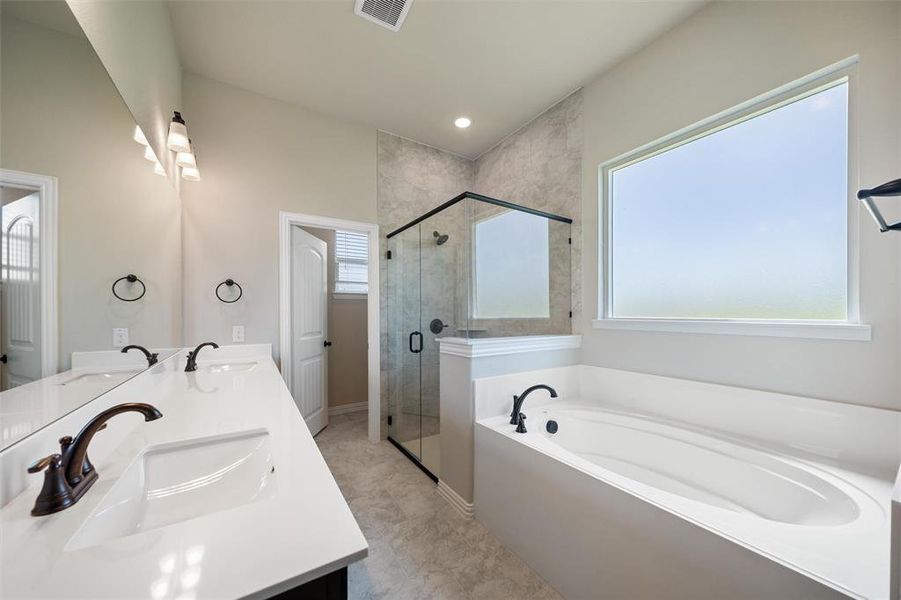 Bathroom featuring a garden tub, double vanity, a shower stall, and recessed lighting Bathroom featuring a garden tub, double vanity, a shower stall, and recessed lighting