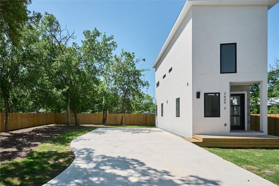 Rear view of house with a patio area, a fenced backyard, and stucco siding