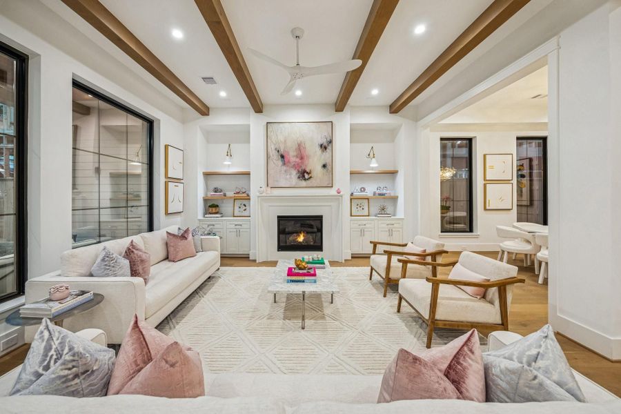 Another view of the Family Room with 42 Inch Direct Vent Gas Fireplace, Cast Stone Surround, Inset, Shaker Style Cabinets/Drawers, White Oak Floating Shelves with a Natural Stain, and Two Anabiya Iron Swing Arm Sconces with White/Brass Gold Finish.