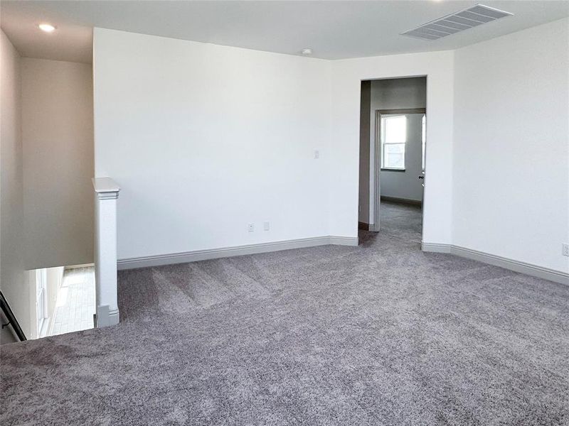 Carpeted spare room featuring baseboards and visible vents