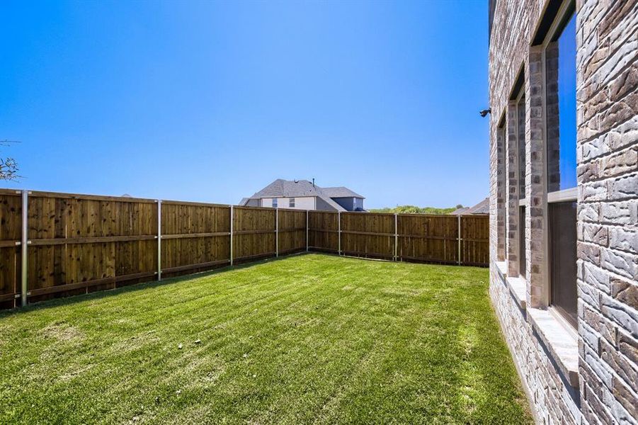 Expansive backyard featuring a lush lawn and a newly installed wood privacy fence