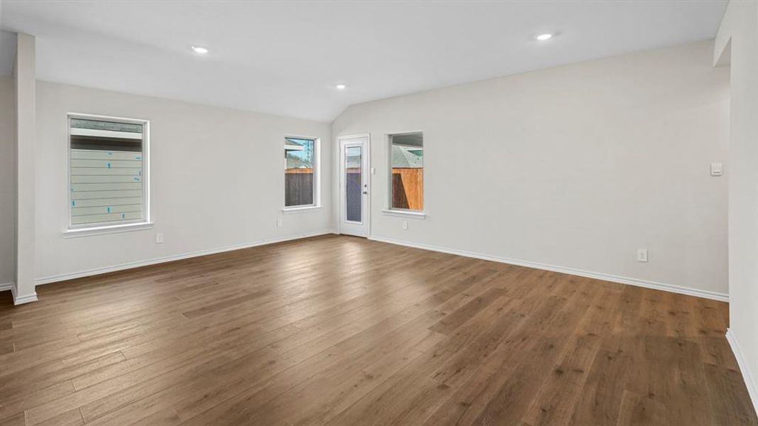 Spare room featuring dark wood-style flooring, recessed lighting, and lofted ceiling