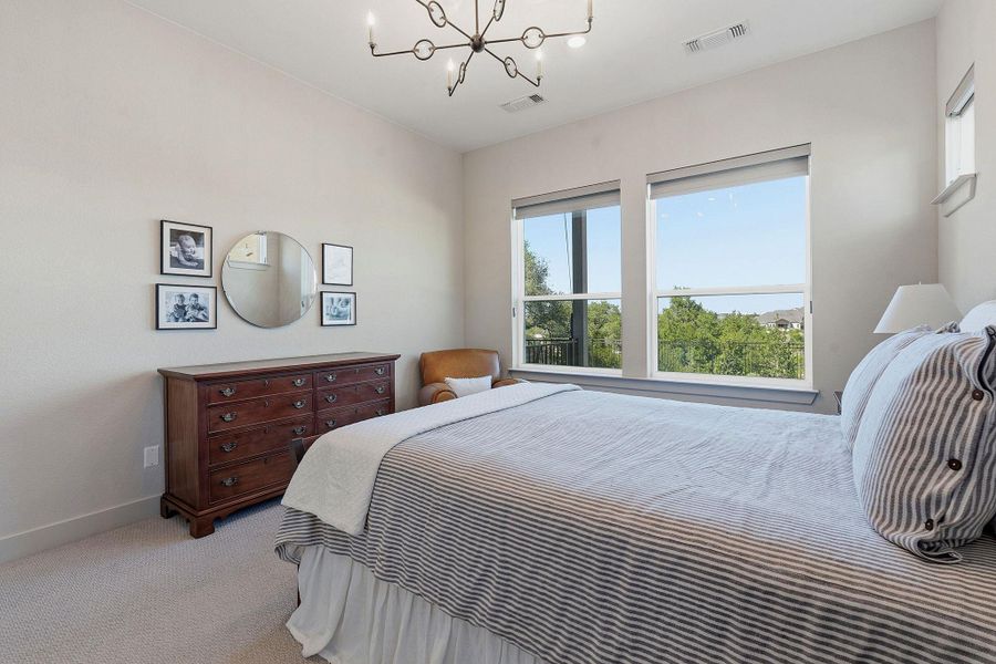 Bedroom with suspended lighting and light colored carpet Bedroom with suspended lighting and light colored carpet